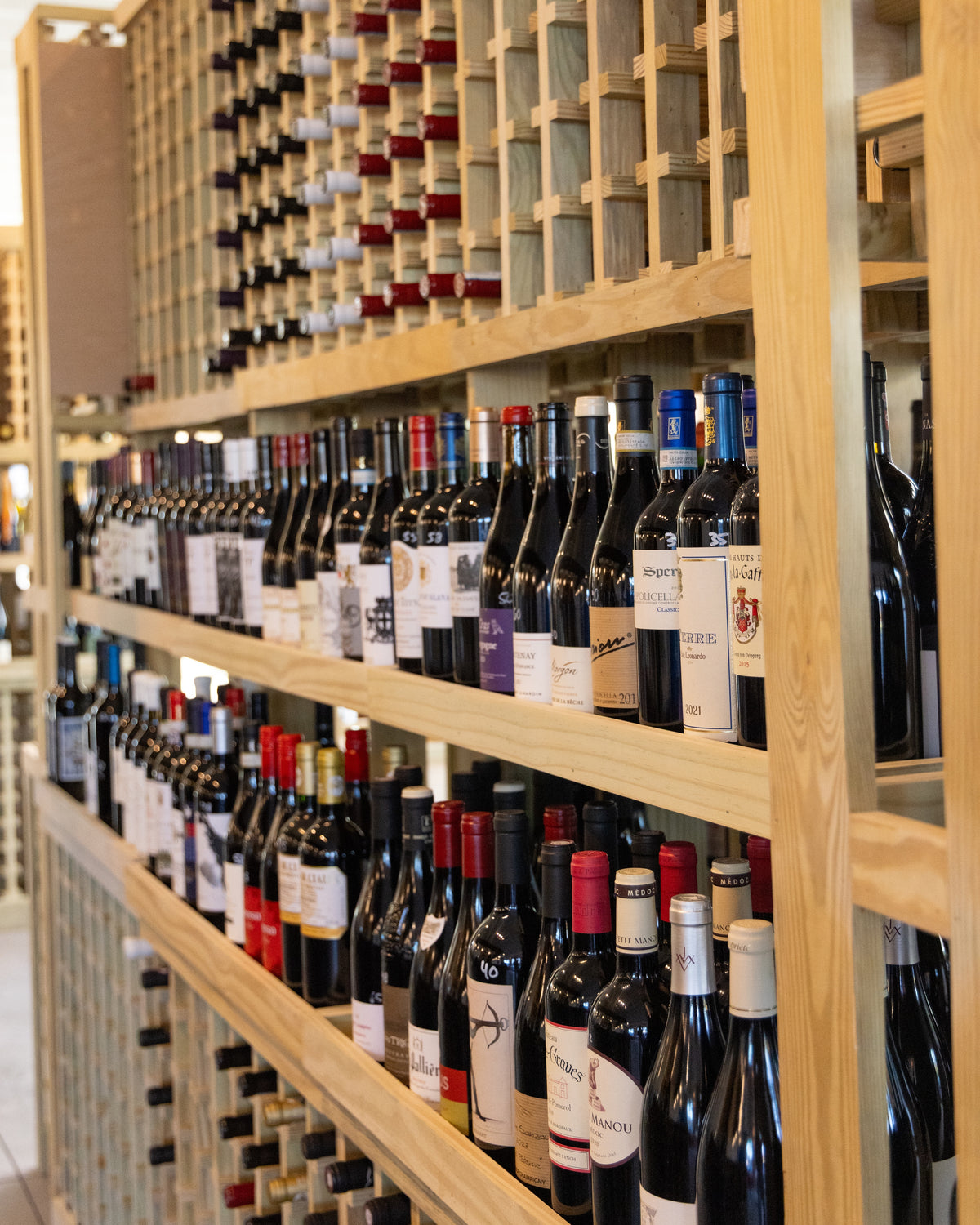 Wine racks and table seating inside SOMM Wine Bar at Nexton