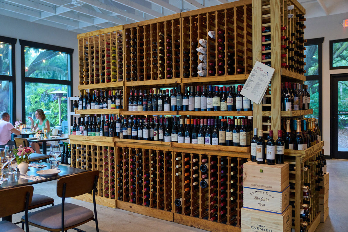 Wine racks and table seating inside SOMM Wine Bar at Nexton